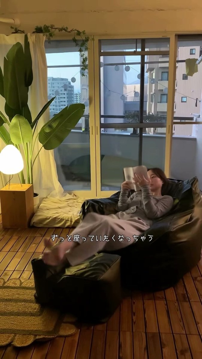 窓辺のソファで本を読む人
