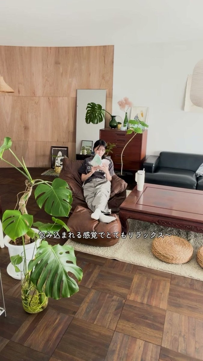 既存の黒いソファのそばで、茶色のLOOSYに座って本を読む人